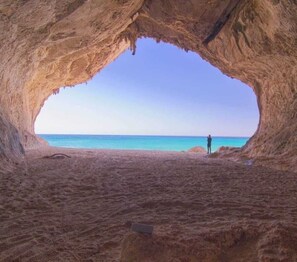 Eine höhlenartige Struktur mit Blick auf Strand und Meer.