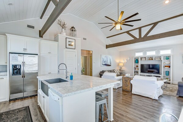 A spacious kitchen with a large island, built-in appliances, and a ceiling fan. - Sea La Vie 2 bedroom 2 bath, pet-friendly home that sleeps 9. (Crystal Beach)