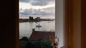 A view through a window with a vase on the sill.