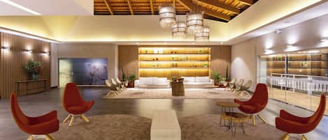A spacious lobby with a high ceiling, modern furniture, and a central seating area.