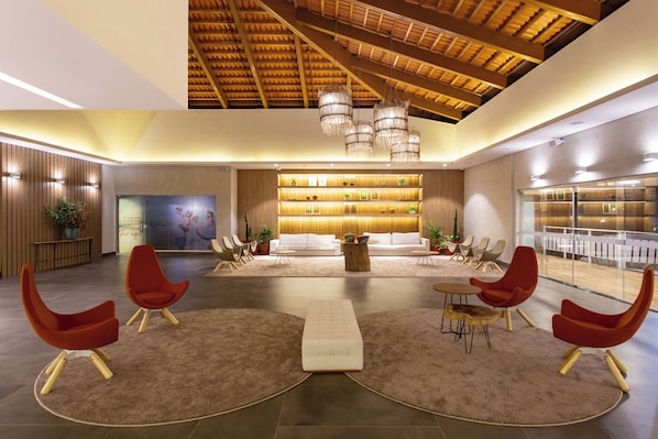 A spacious lobby with a high ceiling, modern furniture, and a central seating area. - Ondas Praia Resort by WAM Experience (Porto Seguro)