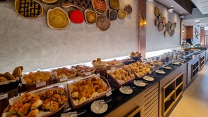 A buffet with various baked goods and a wall decorated with wooden plates. - Ondas Praia Resort by WAM Experience (Porto Seguro)