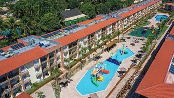 A hotel with multiple swimming pools, a water park, and a rooftop with solar panels.