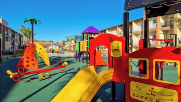 A children's play area with a slide, seesaw, and various play structures.
