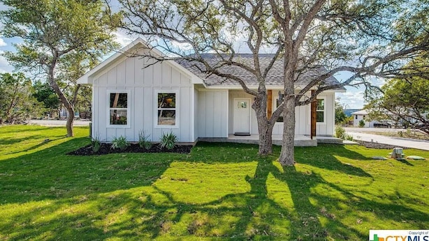 A single-story house with a gabled roof, a front porch, and a well-maintained lawn. - Fun New Lake House! (Canyon Lake)