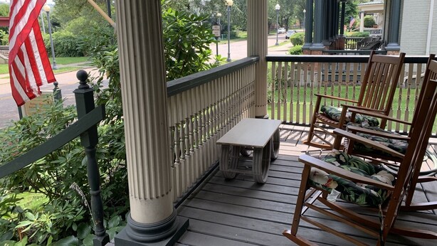 A porch with a flag, a bench, and rocking chairs. - Beautiful Victorian Home (Steubenville)