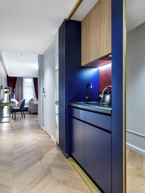 A modern kitchen with a dark blue cabinet, a kettle, and a countertop. - Hotel Golden Queen (Kraków)