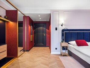 A hotel room with a bed, bedside table, and a mirror. - Hotel Golden Queen (Kraków)