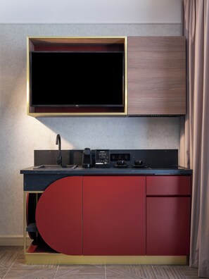 A modern kitchen with a built-in TV, a coffee machine, and a sink. - Hotel Golden Queen (Kraków)