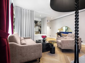 Un salon moderne avec deux canapés, une table basse et une table d’appoint sur laquelle est posé un vase de fleurs.