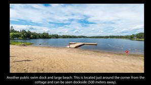 A public swim dock and large beach area near a cottage, with a dockside view visible 500 meters away.
