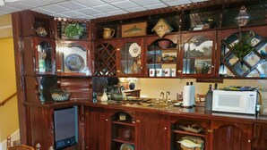 Una cocina con gabinetes de madera, un microondas y varios utensilios.