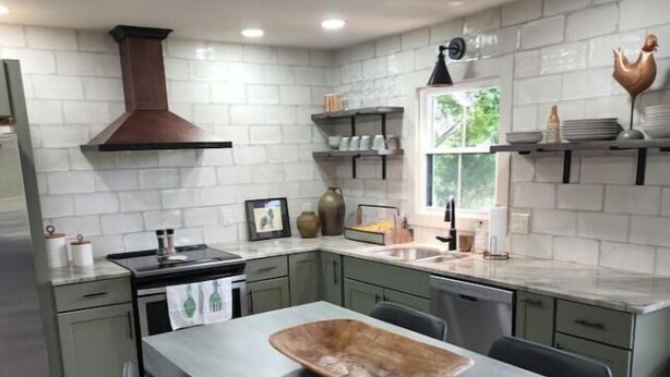 Una cucina moderna con isola centrale, mobili a incasso e una finestra che permette l'illuminazione naturale.