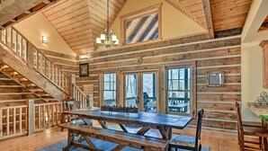 A rustic wooden interior with a large dining table, benches, and a staircase leading to an upper level. - Hot Tub & Fire Pit: Getaway Near Nantahala Gorge! (Franklin)