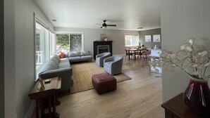 Un salon spacieux avec un canapé gris, une table basse et une cheminée.