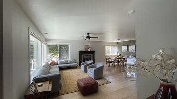 A spacious living room with a gray sofa, a coffee table, and a fireplace.