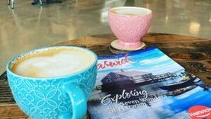 L'intérieur d'un café, avec une table, des chaises et un présentoir à menus.