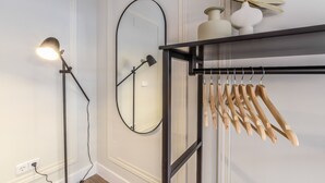 A room with a mirror, a lamp, and a shelf with wooden hangers. - Spectacular design apartment in the center SB 1 (Madrid)