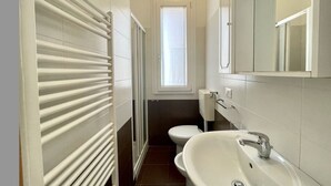 Un baño pequeño con inodoro, lavabo y radiador.