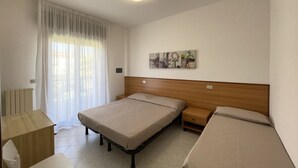 Une chambre à coucher avec un lit, des tables de chevet, un bureau et un radiateur.
