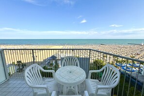 A balcony with a view of a crowded beach and a clear sky. - Appartamento Centro  Commerciale 2 - Carraro Immobiliare Jesolo (Lido di Jesolo)