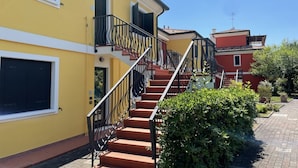 Un bâtiment jaune avec un escalier menant à un balcon.