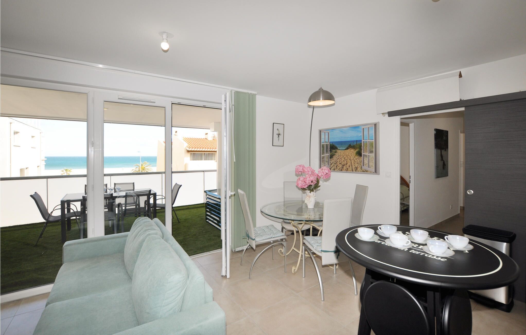 A modern apartment with a balcony, a dining area, and a living room.