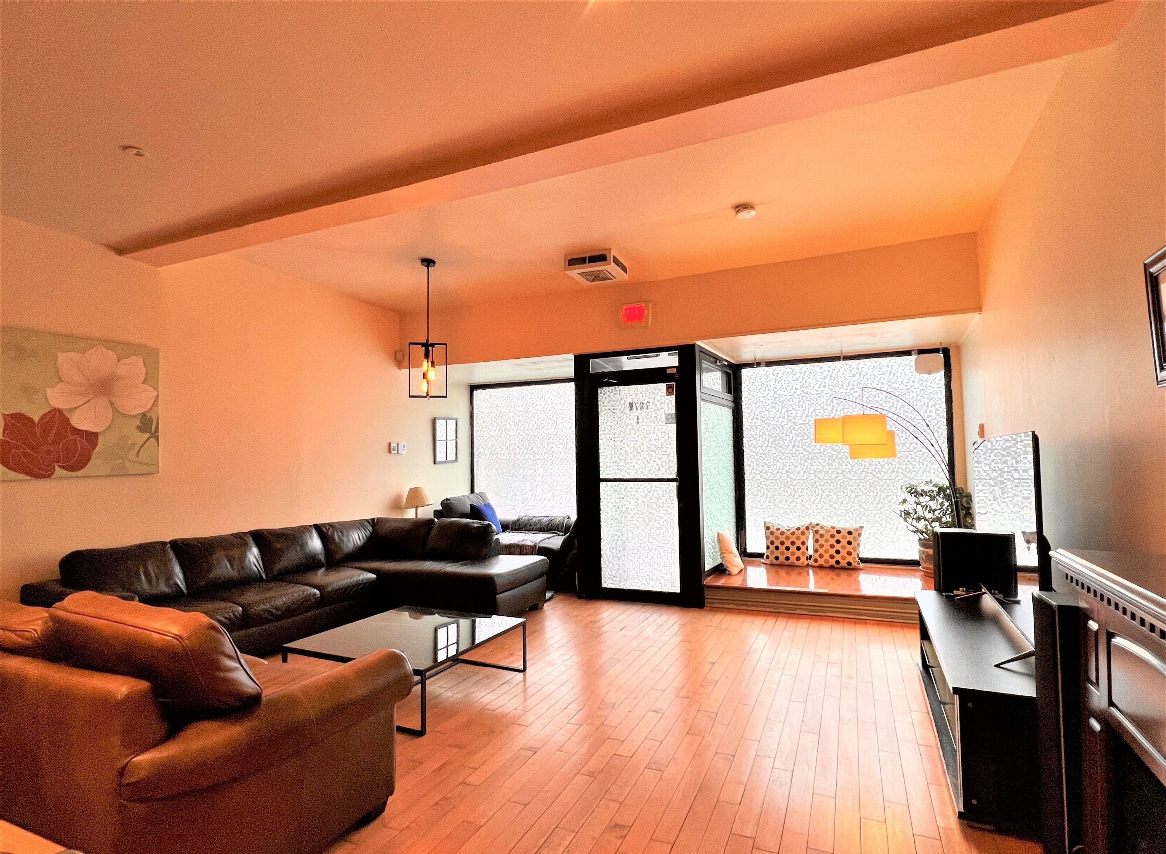 A modern living room with a leather sofa, a coffee table, and a television.