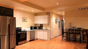 A modern kitchen with stainless steel appliances, white cabinetry, and a wooden floor. - A1~Loft with Games~Gathering 20+ppl~100 Walk Score (Montréal)
