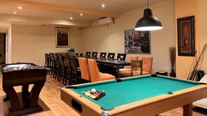A pool table with balls, a foosball table, and a dining area with chairs and a table. - A1~Loft with Games~Gathering 20+ppl~100 Walk Score (Montréal)