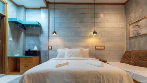 Un dormitorio con una cama grande, una mesita de noche de madera, un escritorio y un estante en la pared.