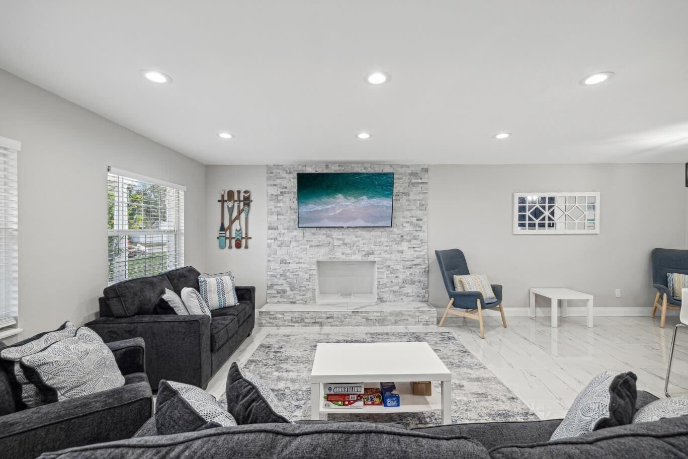 A modern living room with a fireplace, a sofa set, a coffee table, and a TV mounted on the wall.