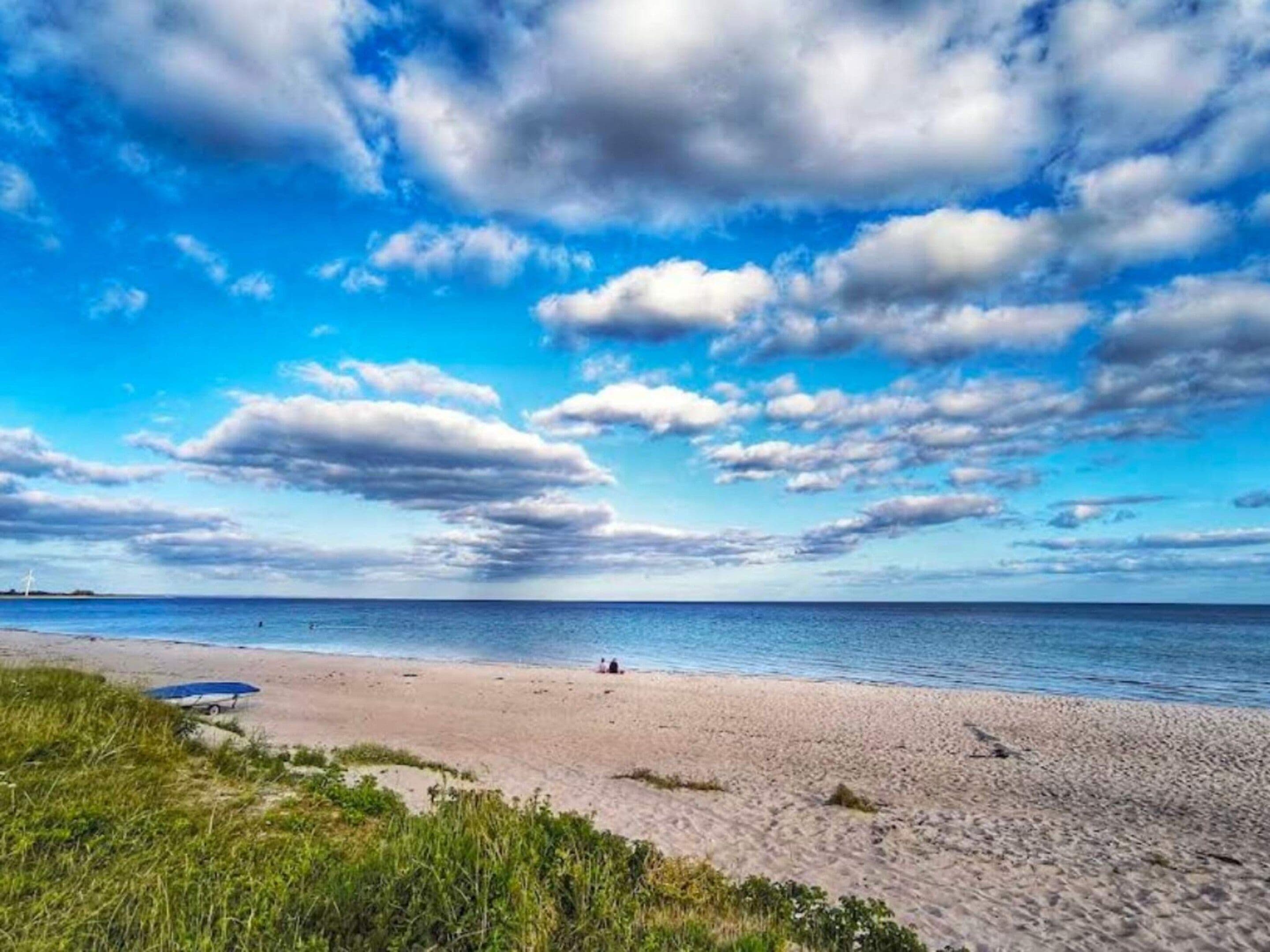A beach with a clear sky and a boat on the sand.