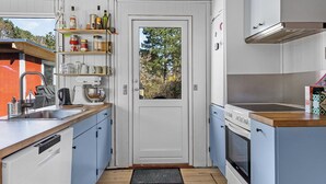 Una cocina compacta con horno integrado, cafetera y lavabo.