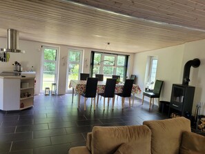 A modern living room with a dining area, a fireplace, and large windows. - Lovely holiday home with spa and hot tub outside (Hals)