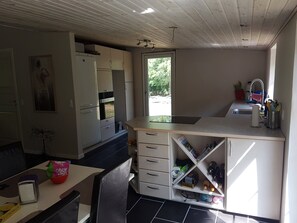 A compact kitchen with white cabinets, a built-in oven, a sink, and a window providing natural light. - Lovely holiday home with spa and hot tub outside (Hals)