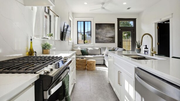 Una cucina moderna con forno integrato, piano cottura a gas e una grande isola con lavello.