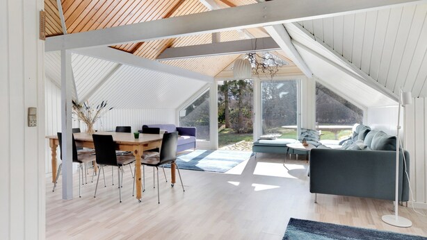 Ein modernes Interieur mit Essbereich, einer Sitzecke und einem großen Fenster.