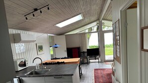 Eine Küche mit Spüle, Schränken und einem Essbereich mit Tisch und Stühlen.