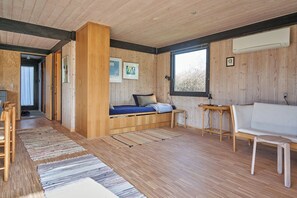 Une pièce avec un lit, un canapé, une petite table et une fenêtre.