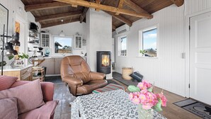 A cozy living room with a fireplace, leather chair, and a sofa. - Holiday idyll between fjord and sea (Hvide Sande)