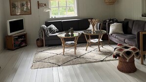 Un salon chaleureux aménagé dans les combles, avec un plafond en pente, une grande fenêtre, un canapé, un téléviseur et une cheminée.