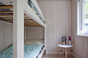 A bunk bed room with a small table and a heater.