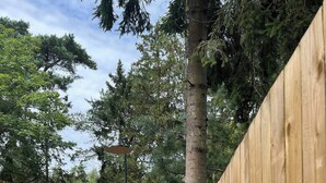 A wooden fence with a gate, a tree, and a clear sky. - Charmantes Sommerhaus in der Nähe eines fantastischen Sandstrandes (Åkirkeby)