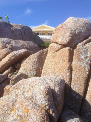 Grandes rocas con un edificio al fondo.