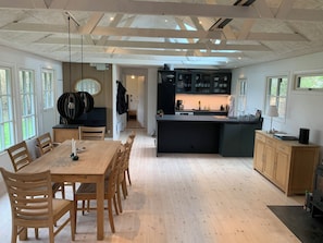 A modern kitchen with a central island, wooden dining table, and chairs.