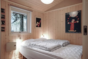 Un dormitorio con cama, ventana, un cartel y un termostato.