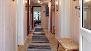 A hallway with wooden walls, a bench, and a door. - Nice summer house in the middle of the forest (Store Fuglede)