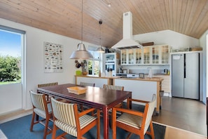 A modern kitchen with wooden cabinets, a built-in oven, and a large refrigerator.