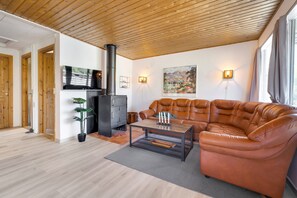 A living room with a leather sofa, a coffee table, a fireplace, and a television.